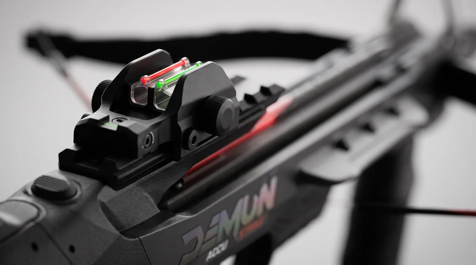 Close-up of a red and green fiber optic pistol sight on a matte black sight housing