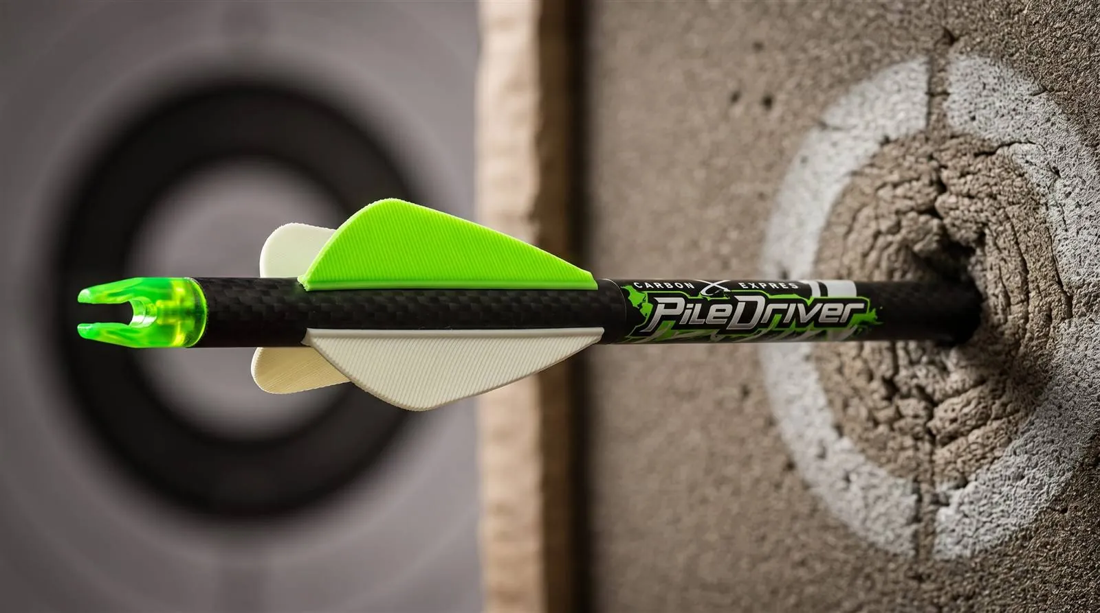 A PileDriver bolt buried in a foam target with its fusion vanes visible behind the impact point