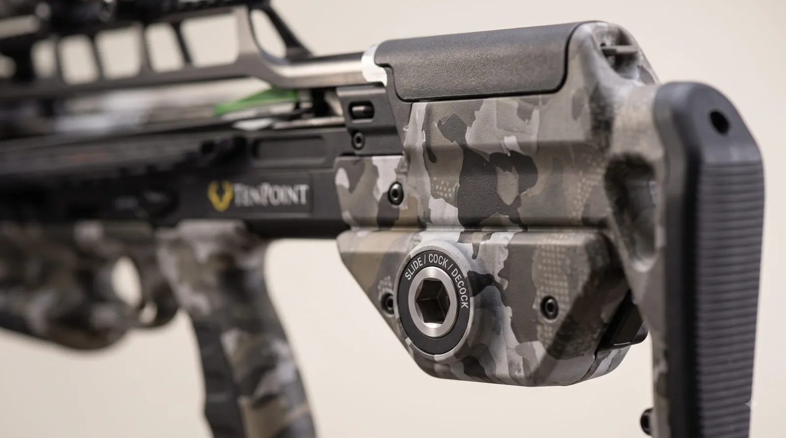 Close-up of an integrated crossbow cocking mechanism rail and control switch in brushed metal and polymer